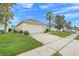 Exterior angle of home and driveway showcasing landscaping and side entry garage in a well-maintained yard at 915 Lockbreeze Dr, Davenport, FL 33897