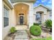 Inviting covered entryway featuring a decorative wreath on the front door, offering a warm welcome at 915 Lockbreeze Dr, Davenport, FL 33897