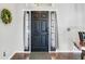 Elegant dark wood front door with side lights and transom window, complemented by a decorative wreath at 915 Lockbreeze Dr, Davenport, FL 33897