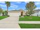 Charming single-story home with a well-maintained lawn, palm tree, and two-car garage at 915 Lockbreeze Dr, Davenport, FL 33897