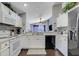 Bright kitchen featuring white appliances, cabinetry, and views into the adjacent living area at 915 Lockbreeze Dr, Davenport, FL 33897