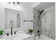 Bathroom featuring a marble-tiled shower/tub, modern fixtures, and neutral decor at 1002 Cypress Ave, Sanford, FL 32771