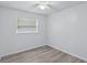 Simple, bright bedroom with a ceiling fan, window, and light wood-look flooring at 1002 Cypress Ave, Sanford, FL 32771