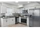 Modern kitchen with white cabinets, granite countertops, and stainless steel appliances at 1002 Cypress Ave, Sanford, FL 32771