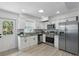 Bright kitchen featuring stainless steel appliances, granite counters, and white cabinetry at 1002 Cypress Ave, Sanford, FL 32771