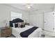 Bedroom with a padded headboard bed, bedside tables, ceiling fan, and natural light at 1002 Cypress Ave, Sanford, FL 32771