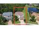 Aerial view showcases home's position in a lush, green landscape with a tranquil pond nearby at 1016 Fountain Coin Loop, Orlando, FL 32828