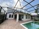 Backyard view of the house and pool, with a screened enclosure and brick-paved deck at 1016 Fountain Coin Loop, Orlando, FL 32828
