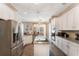 Bright kitchen features stainless appliances, granite countertops, white cabinets, central island and tile flooring at 1031 Kings Hwy, Kissimmee, FL 34744