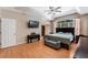 Spacious main bedroom features wood flooring, ceiling fan, tray ceiling and large window with curtains at 1031 Kings Hwy, Kissimmee, FL 34744