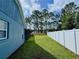 Expansive backyard features lush green grass and a white fence, perfect for outdoor activities at 10747 Satinwood Cir, Orlando, FL 32825