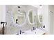 Stylish bathroom featuring dual sinks, modern fixtures, unique mirrors, and designer tile at 10747 Satinwood Cir, Orlando, FL 32825