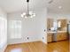 Bright dining area with modern chandelier, hardwood floors, and updated kitchen access at 10747 Satinwood Cir, Orlando, FL 32825