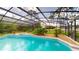 Inviting screened pool area with lush landscaping and a relaxing spa at 10747 Satinwood Cir, Orlando, FL 32825