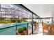 Screened-in lanai with pool, dining table, chairs, and manicured landscaping at 10747 Satinwood Cir, Orlando, FL 32825