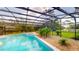 This screened-in pool and spa area features rock landscaping and a relaxing backyard view at 10747 Satinwood Cir, Orlando, FL 32825