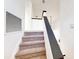 Carpeted staircase with a sleek black handrail, leading to the upper level at 10747 Satinwood Cir, Orlando, FL 32825