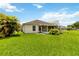 Expansive backyard features lush grass, mature trees, and a screened-in patio, perfect for outdoor living at 10828 Cherry Oak Cir, Orlando, FL 32817