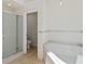 Bright bathroom features a shower with glass doors and a large white bathtub at 10828 Cherry Oak Cir, Orlando, FL 32817