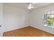 A well-lit bedroom with wood floors, a ceiling fan, and a view through the window at 10828 Cherry Oak Cir, Orlando, FL 32817