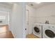 Bright laundry room featuring white appliances and a wire shelf for organized storage at 10828 Cherry Oak Cir, Orlando, FL 32817