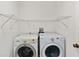 The laundry room has modern washer and dryer with ample storage space above at 10828 Cherry Oak Cir, Orlando, FL 32817