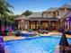 Beautiful backyard at dusk with a pool, spa, waterfall feature, and outdoor lighting enhancing the outdoor living space at 11106 Coniston Way, Windermere, FL 34786