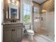 Bright bathroom with a granite topped vanity, tiled floors and shower, and a view to outside at 11106 Coniston Way, Windermere, FL 34786