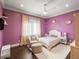 A brightly decorated purple bedroom with a ceiling fan, window, and matching furniture at 11106 Coniston Way, Windermere, FL 34786
