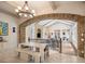 Open-concept dining room featuring a brick archway, chandelier, and white dining table with bench seating at 11106 Coniston Way, Windermere, FL 34786