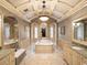 Opulent main bathroom with a large soaking tub, dual vanities, and a decorative chandelier at 11106 Coniston Way, Windermere, FL 34786