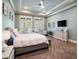 Inviting main bedroom with a tray ceiling, herringbone floors, and french doors with plantation shutters at 11106 Coniston Way, Windermere, FL 34786