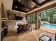 Outdoor kitchen and bar with a view of the pool, waterfall, and lush landscaping at 11106 Coniston Way, Windermere, FL 34786