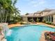 Gorgeous pool and spa with rock waterfall feature, surrounded by lush landscaping in the backyard at 11106 Coniston Way, Windermere, FL 34786