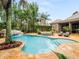 Beautiful pool and spa with natural rock waterfall feature and lush landscaping in a private backyard setting at 11106 Coniston Way, Windermere, FL 34786