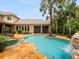 Amazing outdoor pool area with a waterfall, spa, sun loungers, and a glimpse of the outdoor kitchen at 11106 Coniston Way, Windermere, FL 34786