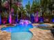 A luxurious pool and spa with tropical landscaping and custom lighting create a backyard paradise at 11106 Coniston Way, Windermere, FL 34786