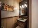 Stylish powder room featuring unique wallpaper, a stone vessel sink, and decorative lighting at 11106 Coniston Way, Windermere, FL 34786