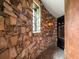 Stone-walled wine room with wine refrigerator and tiled floor next to stylish doorway at 11106 Coniston Way, Windermere, FL 34786