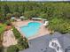 Aerial view of a pool, showing lounge chairs, sunshades, and a view of the clubhouse at 1275 Shallcross Ave, Orlando, FL 32828