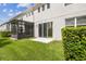 Well-maintained backyard featuring green grass, a screened-in patio, and a neatly trimmed hedge at 1275 Shallcross Ave, Orlando, FL 32828