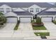 Townhome exterior featuring attached garages, well-manicured landscaping, and a modern design at 1275 Shallcross Ave, Orlando, FL 32828