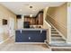 Kitchen area featuring breakfast bar seating, appliances, and staircase access at 1275 Shallcross Ave, Orlando, FL 32828