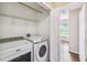 Laundry room featuring a modern washer and dryer set with wire shelving for storage at 1275 Shallcross Ave, Orlando, FL 32828