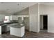 Bright kitchen with granite countertops, island, white cabinets, stainless sink and faucet and wood-look vinyl plank flooring at 14495 Se 38Th Ter, Summerfield, FL 34491