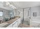 Bright bathroom featuring double sinks, a glass-enclosed shower, and a soaking tub with marble accents at 14680 Yorkshire Run Dr, Orlando, FL 32828