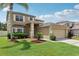 Charming two-story home featuring a manicured lawn, lush landscaping, and a two-car garage at 14680 Yorkshire Run Dr, Orlando, FL 32828