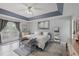Serene main bedroom with tray ceiling, light gray walls, wood-look floors, and private balcony access at 14680 Yorkshire Run Dr, Orlando, FL 32828