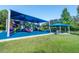 Community playground with a sun-shade covering and picnic pavilion, near well-manicured landscaping at 14680 Yorkshire Run Dr, Orlando, FL 32828