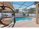 Screened-in pool area with a custom-shaped pool, tiled accents, and a comfortable swing at 14680 Yorkshire Run Dr, Orlando, FL 32828